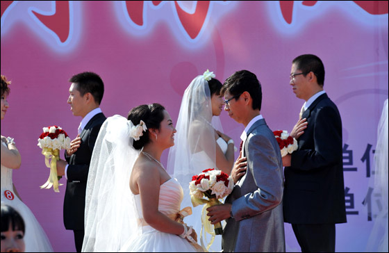  صورة رقم 12 - بالصور.. 21 زوجا صينيا يعقدون قرانهم في حفل زفاف جماعي!! 