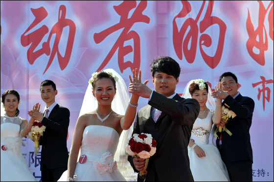  صورة رقم 11 - بالصور.. 21 زوجا صينيا يعقدون قرانهم في حفل زفاف جماعي!! 