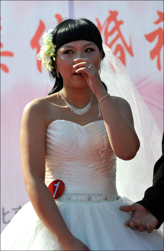  صورة رقم 13 - بالصور.. 21 زوجا صينيا يعقدون قرانهم في حفل زفاف جماعي!! 