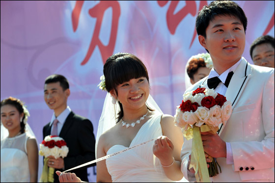  صورة رقم 17 - بالصور.. 21 زوجا صينيا يعقدون قرانهم في حفل زفاف جماعي!! 