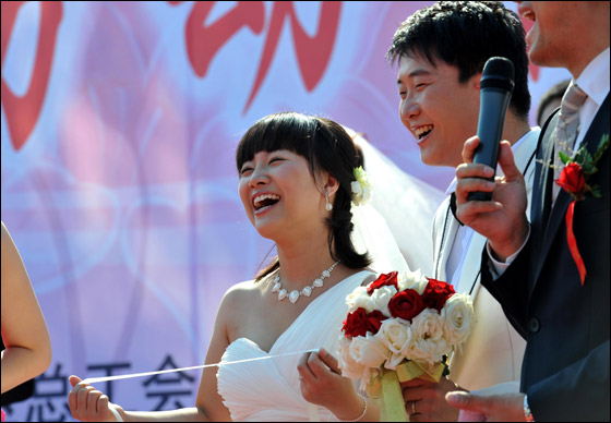  صورة رقم 16 - بالصور.. 21 زوجا صينيا يعقدون قرانهم في حفل زفاف جماعي!! 